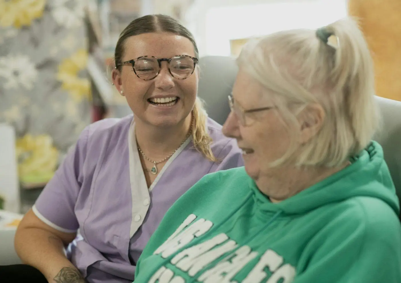 A support worker and an older woman chatting and laughing