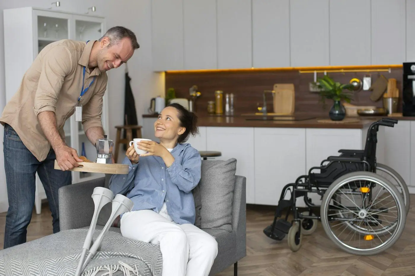 A support worker bringing a cup of tea to a woman relaxing at home
